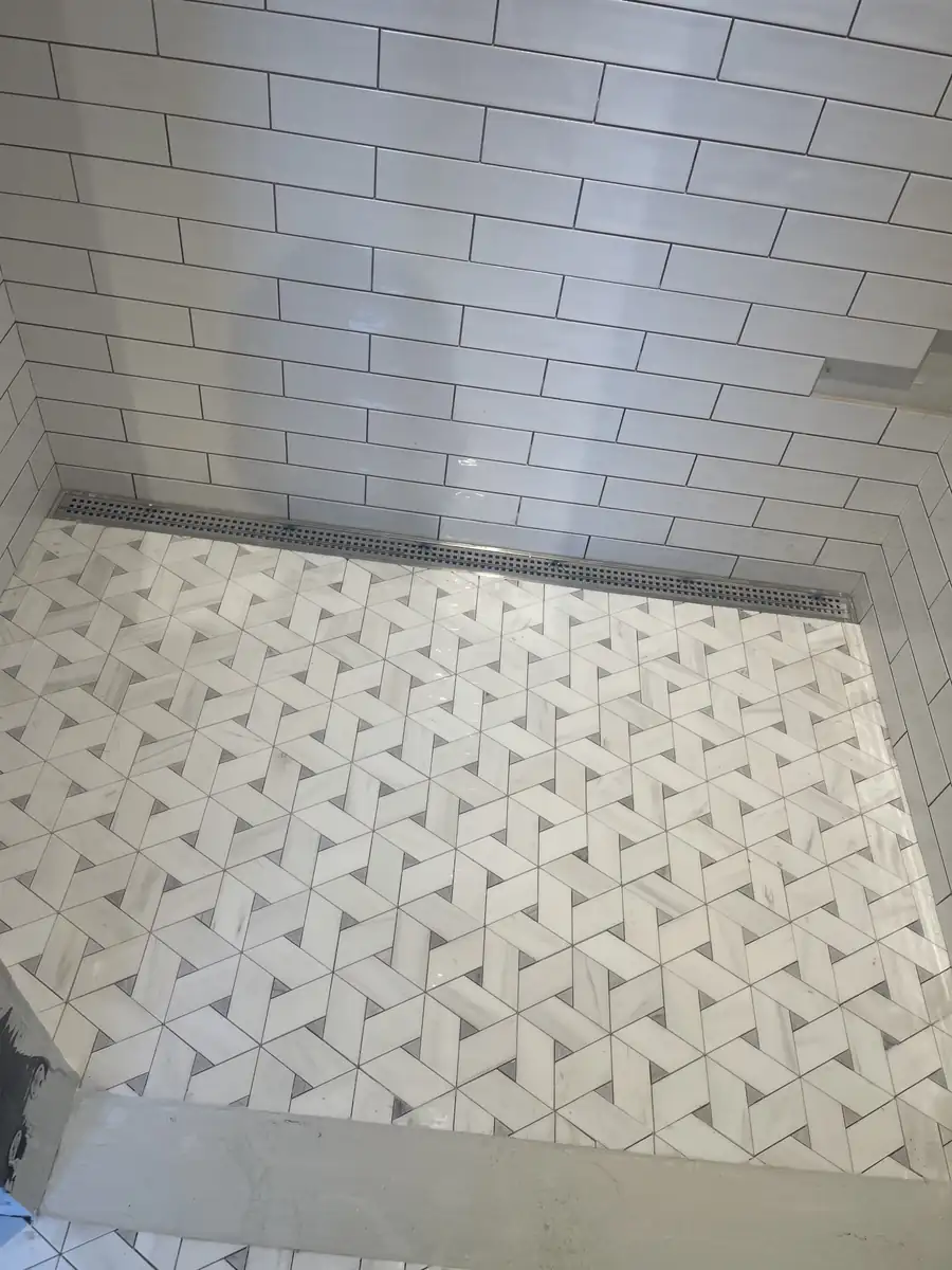 Marble mosaic shower floor with a stainless linear drain